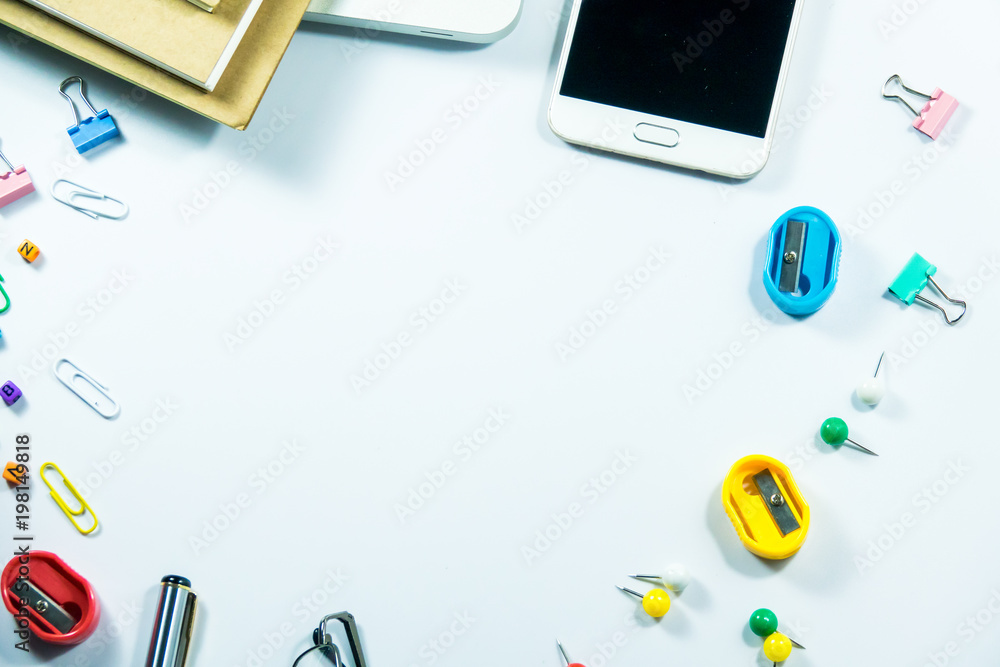 Top view of laptop, blank notebook, paper clips and smart phone with white background and copy space. Top view of laptop, blank notebook, paper clips and smart phone with white background and copy space.