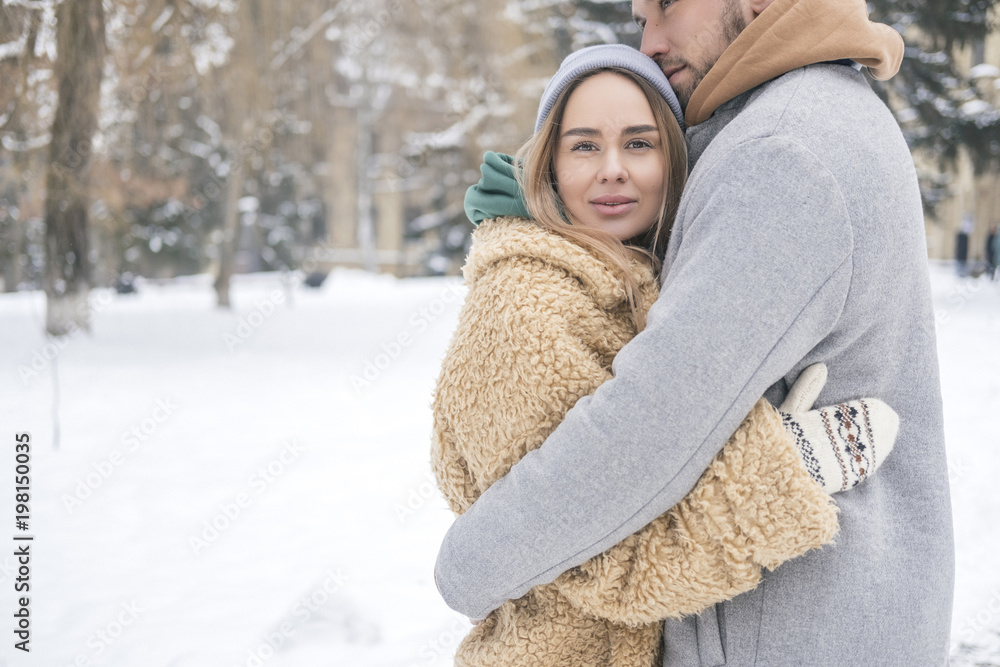 Stylish caucasian couple of man and woman waling in the european city park in winter. Cold, snowy day. Space for text Stylish caucasian couple of man and woman waling in the european city park in winter. Cold, snowy day. Space for text