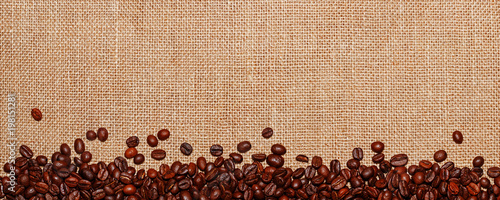Panorama lined with coffee beans on the background of sack cloth