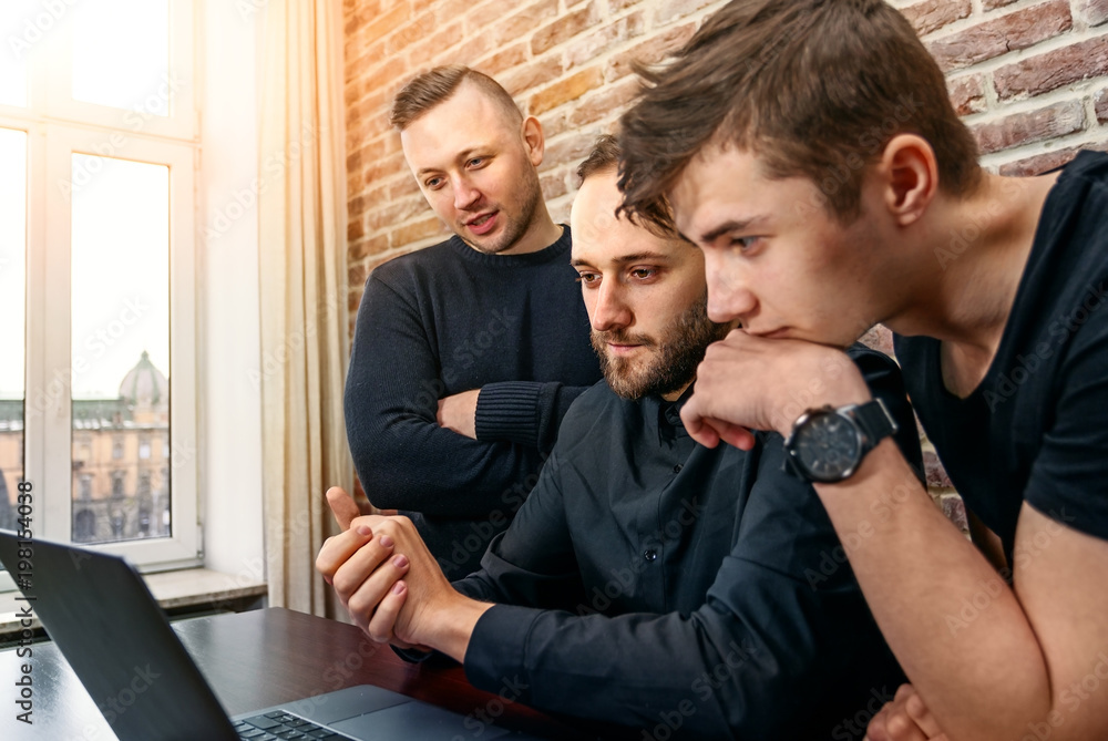 Group of young and creative IT people working in an office. Three programmers looking for successful decision. Group of young and creative IT people working in an office. Three programmers looking for successful decision.