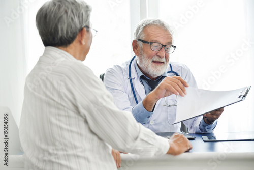 Senior male Doctor is discussing with Asian male patient.