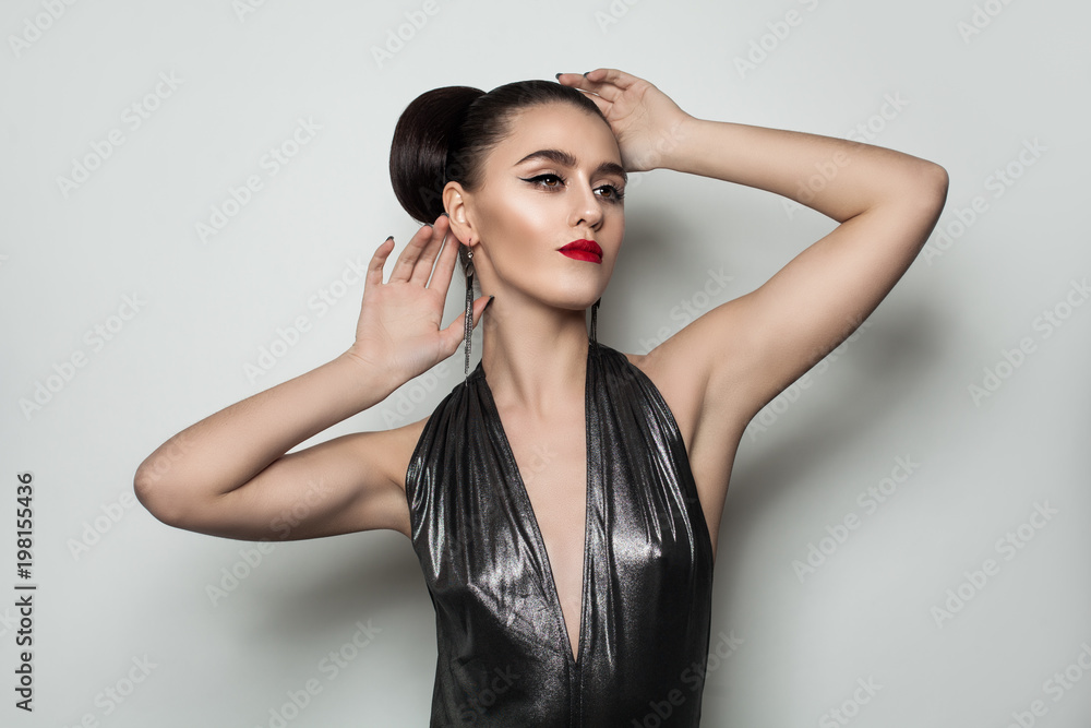 Naklejka premium Beautiful Fashion Model Woman with Event Hairstyle and Makeup Posing on Gray Background