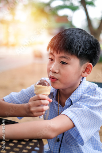 Asia boy eating chocolate ice-cream by happy