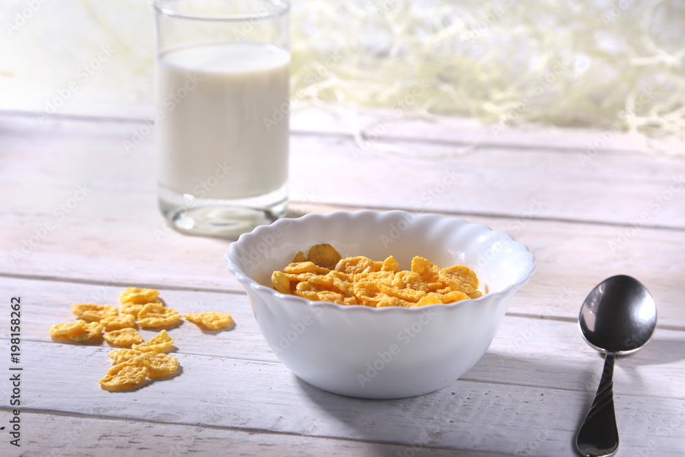Corn Flakes cereal in a bowl and glass with milk. Morning breakfast. Corn Flakes cereal in a bowl and glass with milk. Morning breakfast.