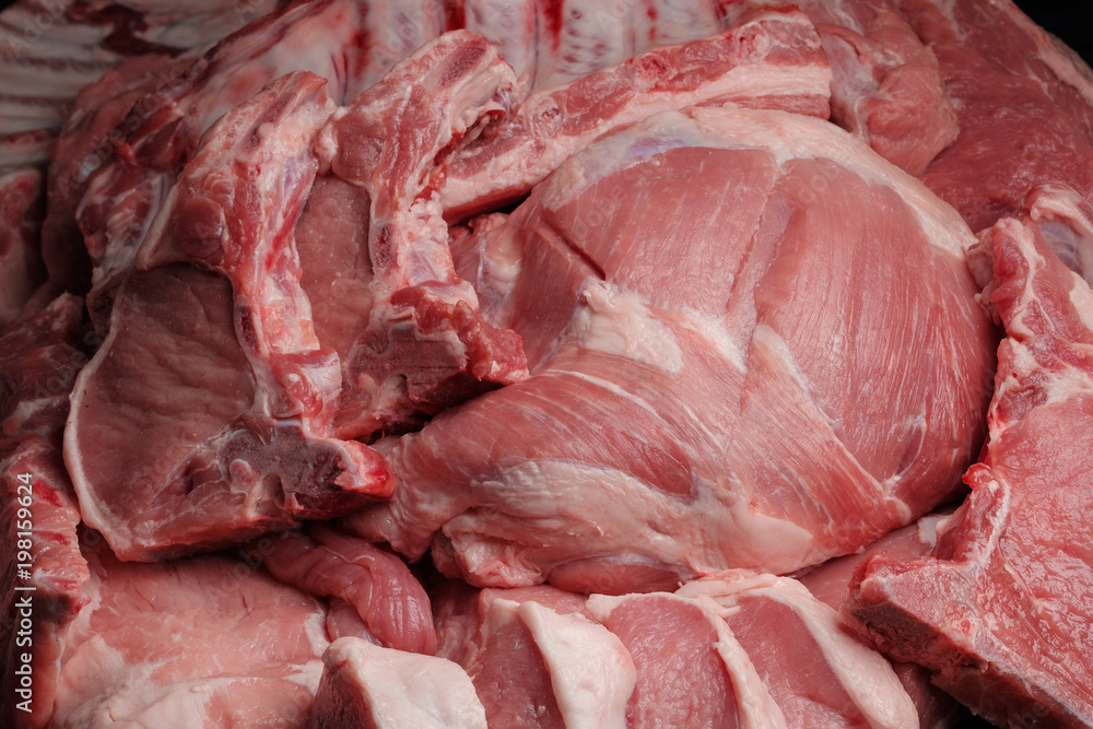 Assortment of raw pork meat: tenderloin, shoulder, neck on a paper background. Close-up