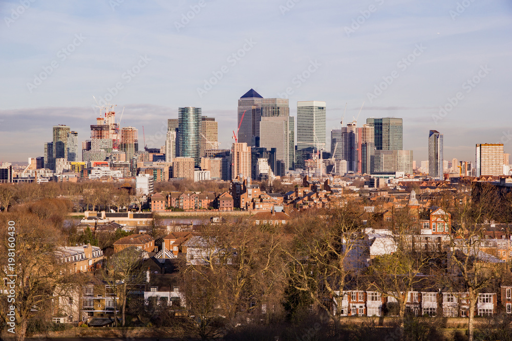 Obraz premium Construction boom continues on the bustling Isle of Dogs or Docklands business district seen from the more traditional setting of Greenwich shown in the foreground