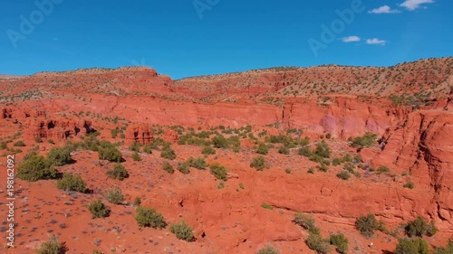 aerial shot flying over some beautiful red cliff formations in the desert