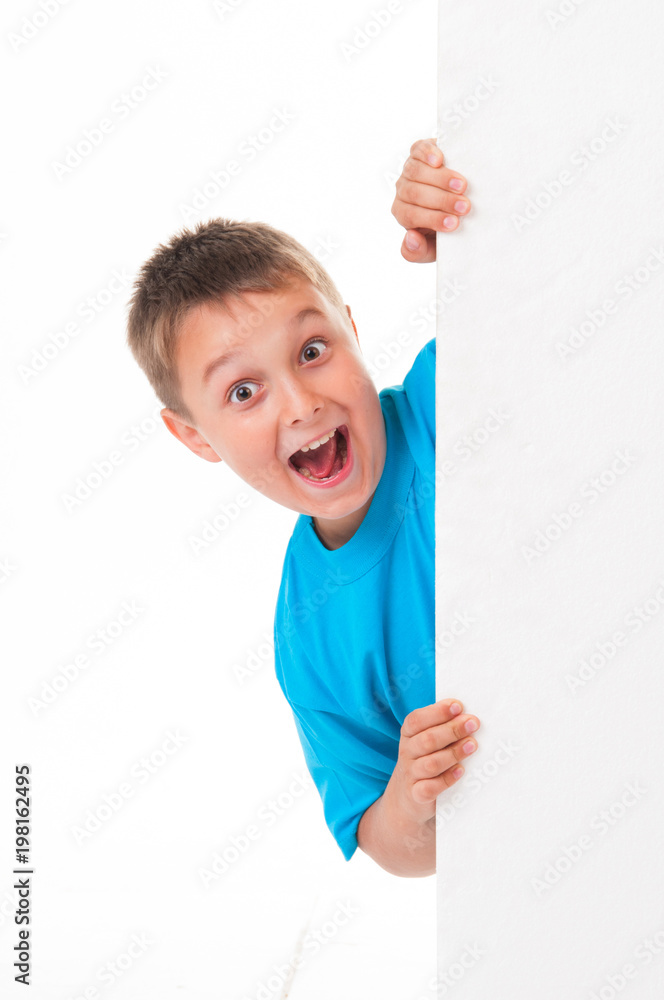 A smiling handsome male posing behind a white panel isolated on white background A smiling handsome male posing behind a white panel isolated on white background