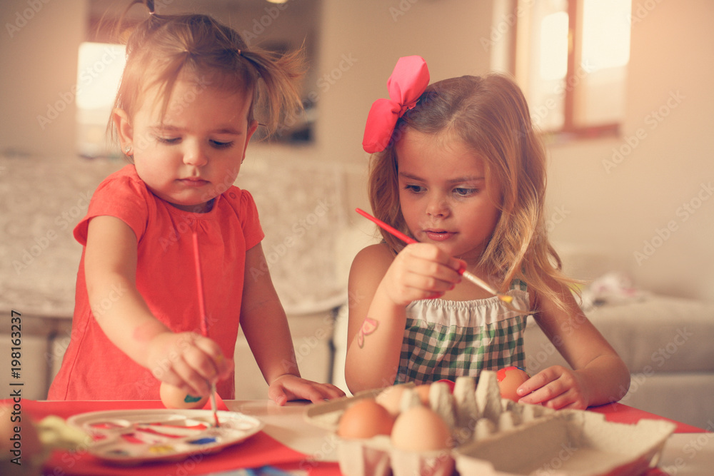 Fototapeta premium Kids Easter preparation by painting Easter eggs.