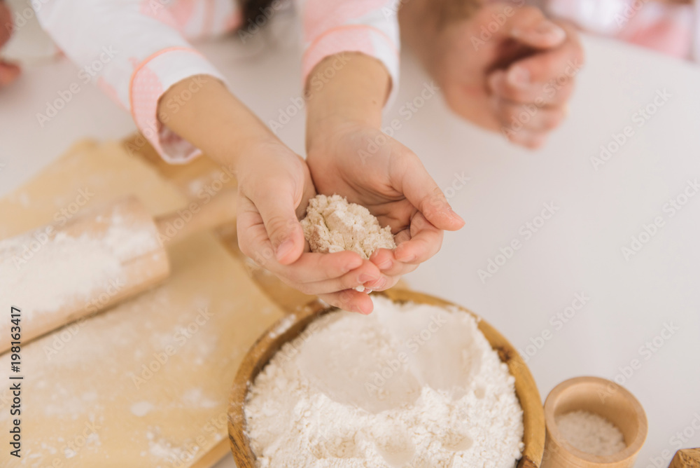 Close up view of bakers are working. Homemade bread. Hands preparing dough on wooden table. Close up view of bakers are working. Homemade bread. Hands preparing dough on wooden table.