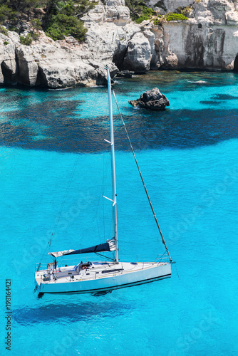 Beautiful bay in Mediterranean sea with sailing boat  Menorca island  Spain. Yachting  travel and active lifestyle concept
