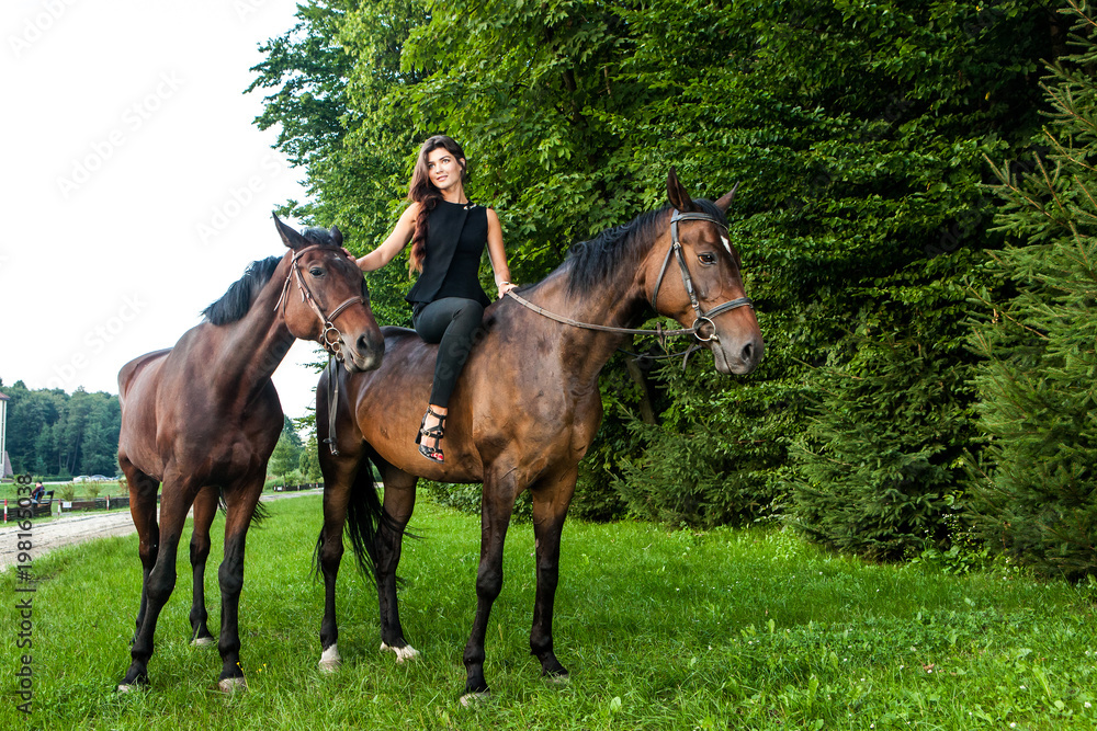 Pretty young woman riding a brown horse