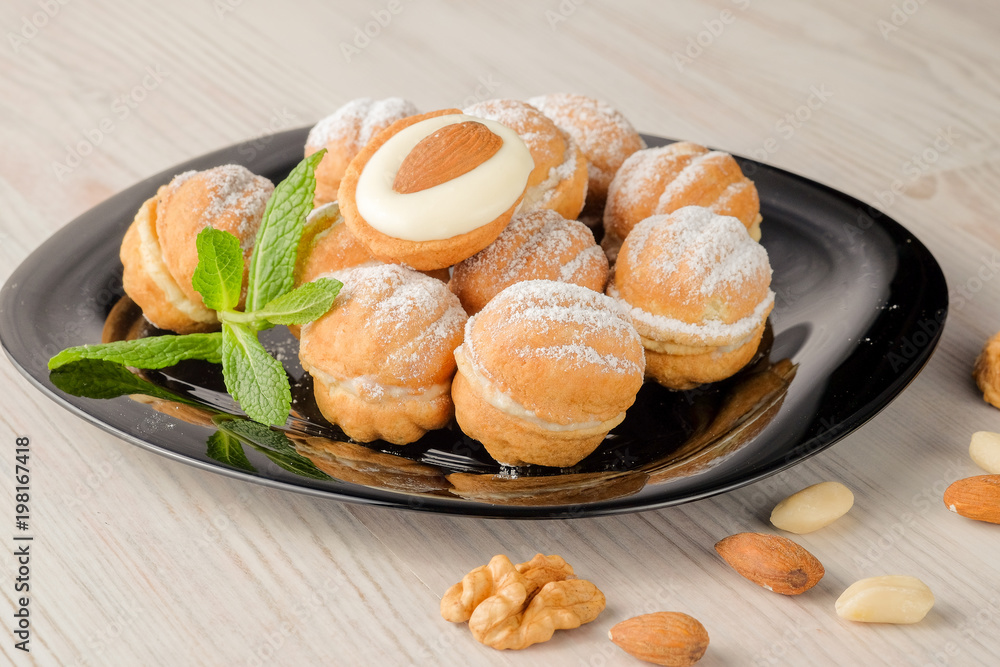 Sweet and delicious russian walnut cookies (filled with condensed milk and almonds) on the dark plate.