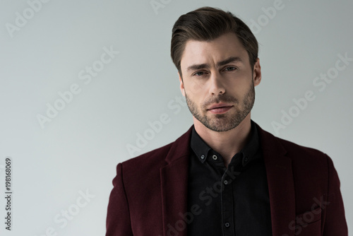 portrait of handsome stylish man posing in jacket, isolated on grey