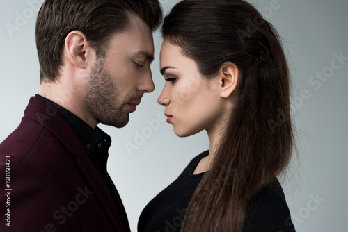 beautiful sensual girlfriend and boyfriend togetherness, isolated on grey