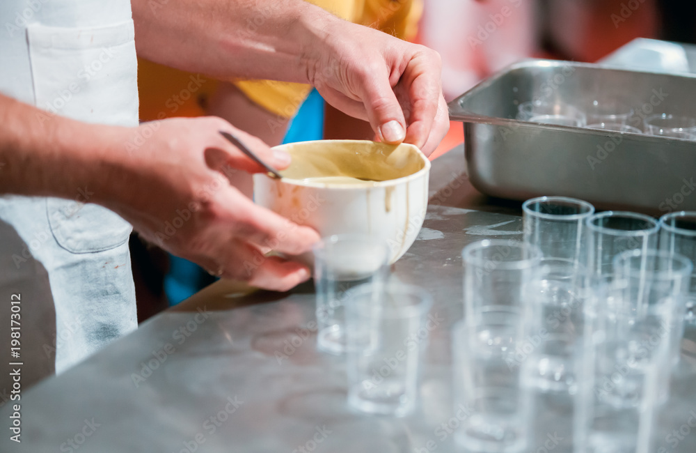 Confectioner preparing cream in pastry shop, food industry Confectioner preparing cream in pastry shop, food industry
