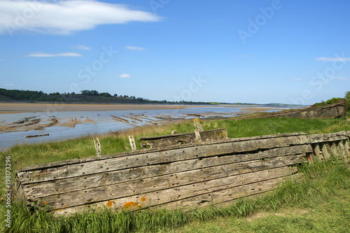 Fototapeta Naklejka Na Ścianę i Meble -  Obsolete old boats and barges were stranded on the banks of the tidal River Severn in Gloucestershire, UK to protect the river banks from erosion. 