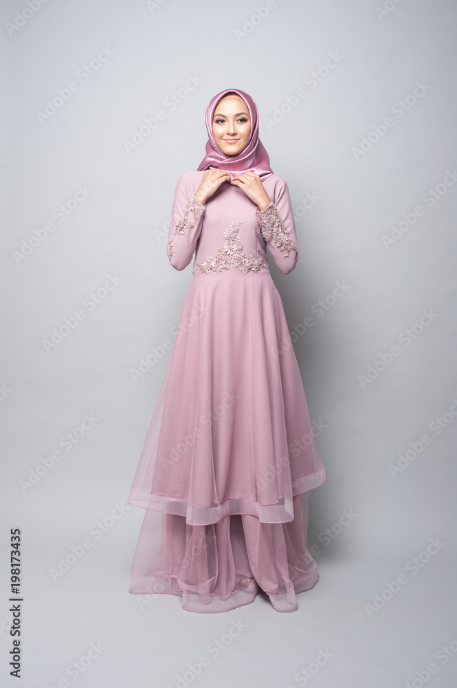 Beautiful muslim girl wearing pink asian dress known as Baju Kurung with Hijab.Hijab fashion for Eid Mubarak.Studio Shoot.