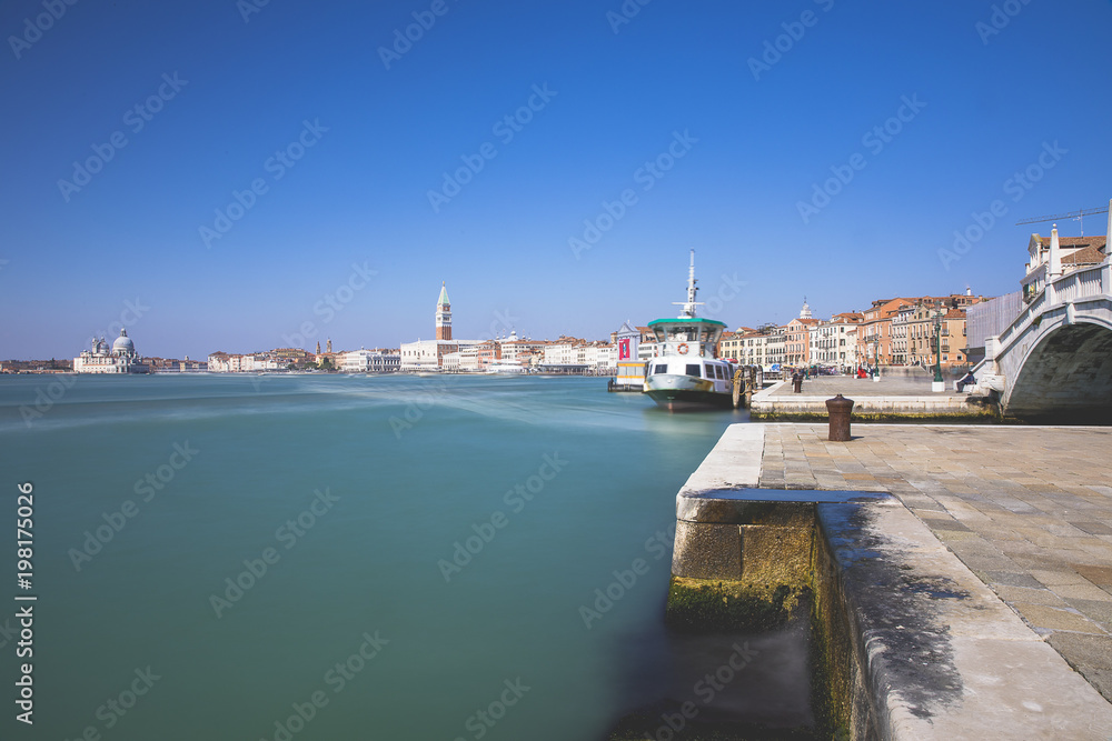 Obraz premium Long exposure view of the blue turquoise lagoon of Venice with the Campanile in the background, Venice, Italy