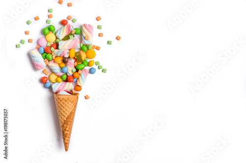Ice cream cone flat lay image with colorful candy packing into the cone.