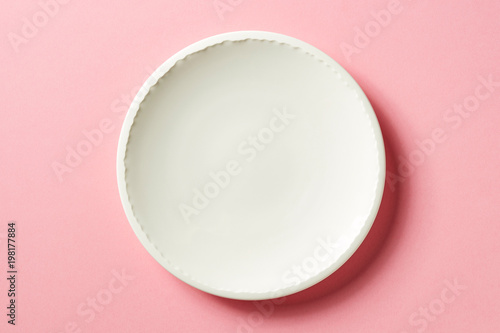 White plate on pink background  from above