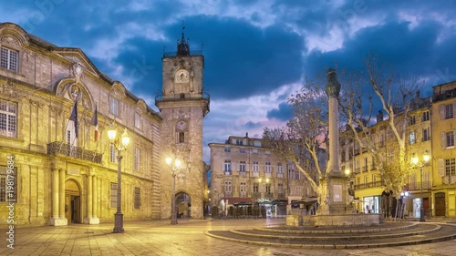 Town hall square at dusk with clock tower and fountain in Aix-en-Provence, France (static image with animated sky)
