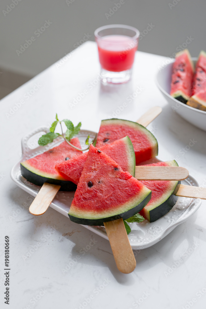 Fresh red smoothie in a glass with sliced pieces of watermelon on table. Fresh red smoothie in a glass with sliced pieces of watermelon on table.