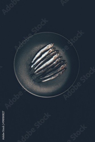 Top view of pile of fish in frying pan isolated on black photo