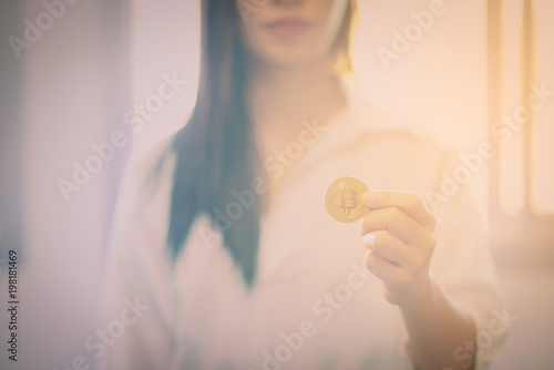 Golden Bitcoin in a man hand, Digitall symbol of a new virtual currency