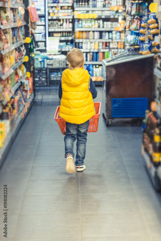 Little boy shopping in supermarket.