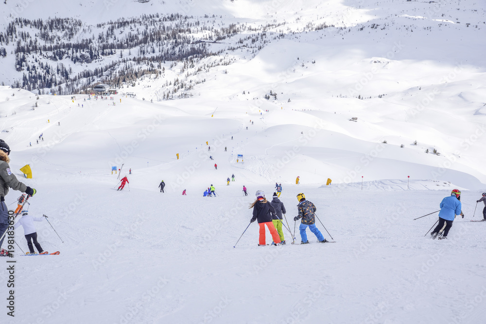 ski slope with skiers in the Alps