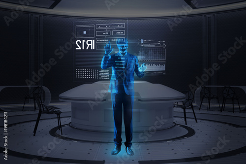 Futuristic technologies. Smart qualified young specialist wearing convenient virtual reality glasses and making a realistic hologram image of himself while standing in a modern office © Viacheslav Yakobchuk