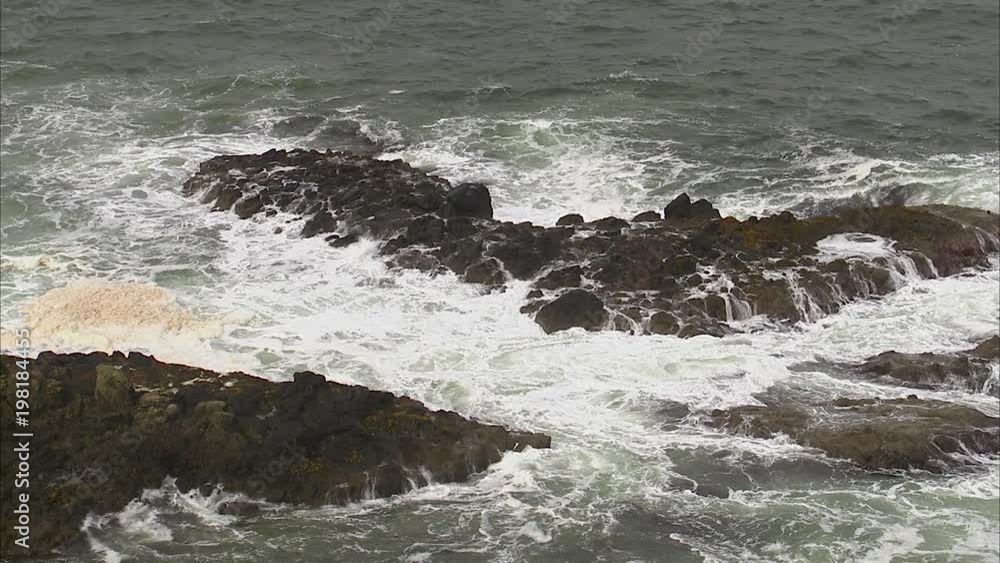A steady shot of a rocky coastline in Ireland. White waves washes the rocks. A steady shot of a rocky coastline in Ireland. White waves washes the rocks.