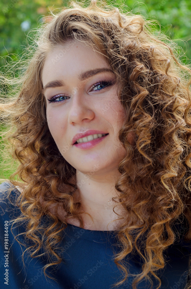 Portrait of a woman with chic curly hair and beautiful light blue eyes.