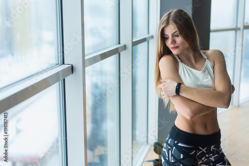 Beautiful athletic girl in sportswear near the panoramic window