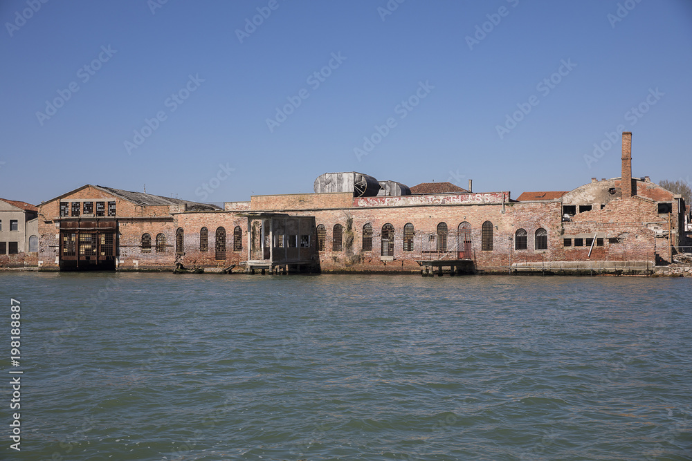 View on an old abandoned glass factory on the island of Murano from the Venice lagoon, Italy