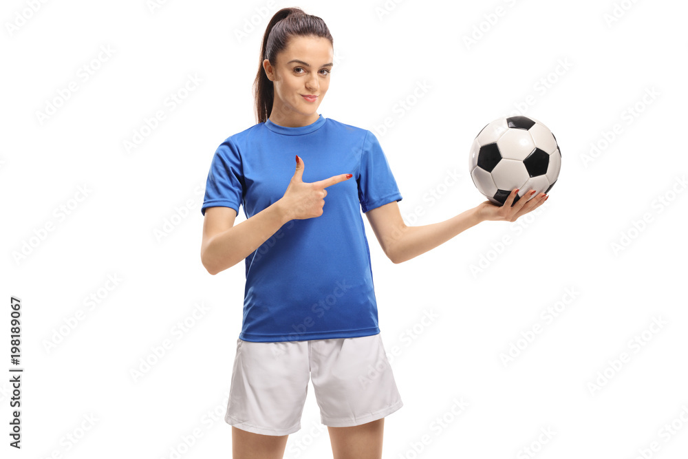 Female soccer player holding a football and pointing