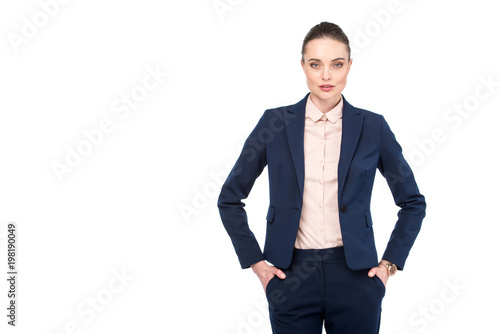 stylish adult businesswoman with hands in pockets looking at camera isolated on white