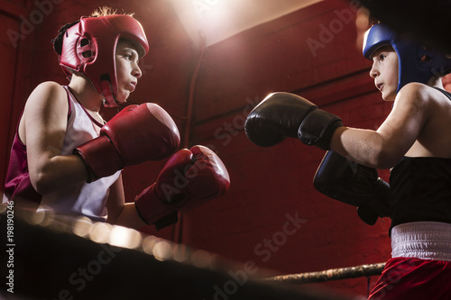 Two young male boxers fitting and training in the ring for a fight