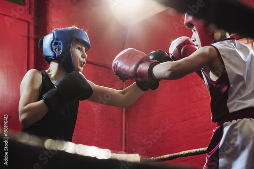 Two young male boxers fitting and training in the ring for a fight
