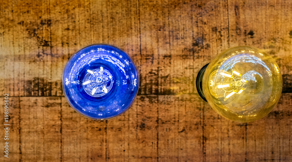 blue and yellow light bulb on wood background blue and yellow light bulb on wood background