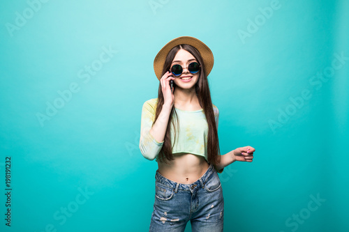 Portrait with copy space of charming, cool, pretty, sexy girl in black glasses, holding smart phone near ear, speaking with friends, having call from her lover, isolated on green background