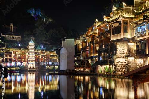 Scenic night view of traditional Chinese wooden riverside houses