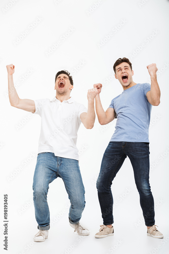 Full length portrait of two happy young men celebrating Full length portrait of two happy young men celebrating