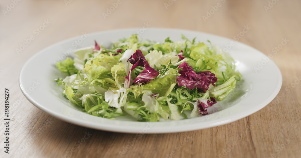 adding olive oil to salad leaves adding olive oil to salad leaves