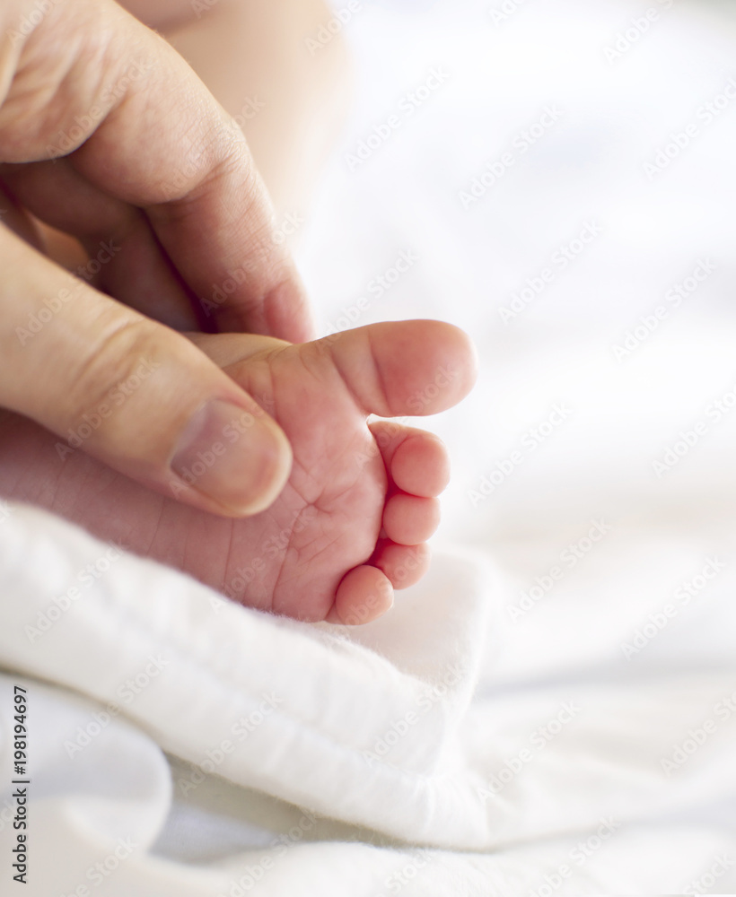 Mother's hand holding baby's foot Mother's hand holding baby's foot