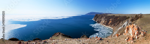Lake Baikal in May sunny day. Panoramic view from the cliffs of Olkhon Island to white ice floes on blue water during the spring ice drift