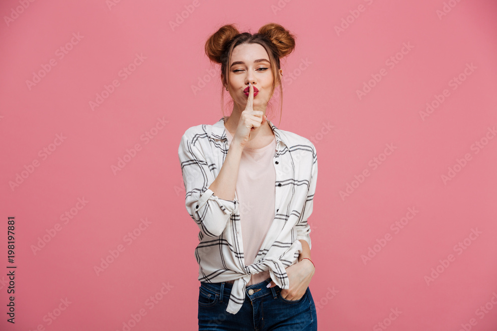 Portrait of a lovely young girl showing silence gesture Portrait of a lovely young girl showing silence gesture