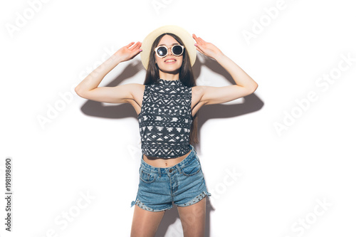 Young beautiful fashionable woman with trendy makeup in black hat and glasses on the grey background .