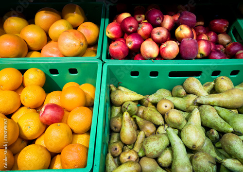 Fruit on display in a supermarket. Oranges, apples and pears.